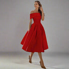 Vrouw in elegante rode off-shoulder jurk, vintage stijl, met wijde rok. Perfect voor feestelijke gelegenheden. Mode, dameskleding, avondjurk.