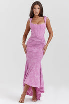 Vrouw in elegante roze avondjurk met bloemenpatroon, strapless ontwerp en asymmetrische zoom. Perfect voor galafeest of bruiloft.