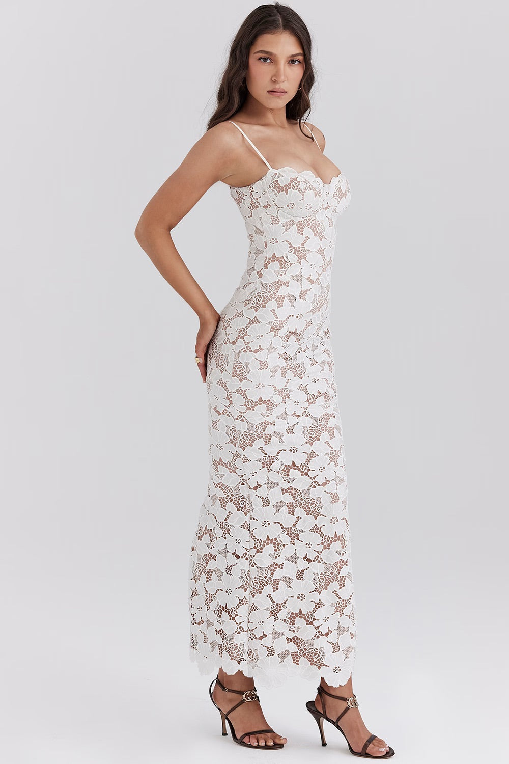 Vrouw in elegante witte kanten jurk, lange mouwloze avondjurk, perfecte pasvorm, modieuze kleding, geschikt voor bruiloften en speciale gelegenheden.